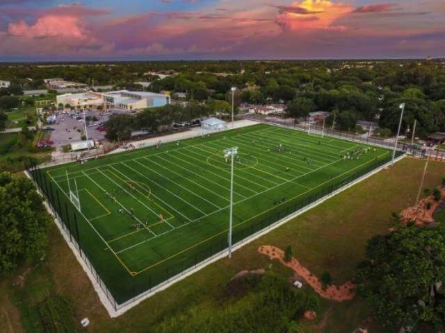 A view of the Sarasota soccer field at the Robert L. Taylor Complex, featuring green grass and goalposts under a clear sky.